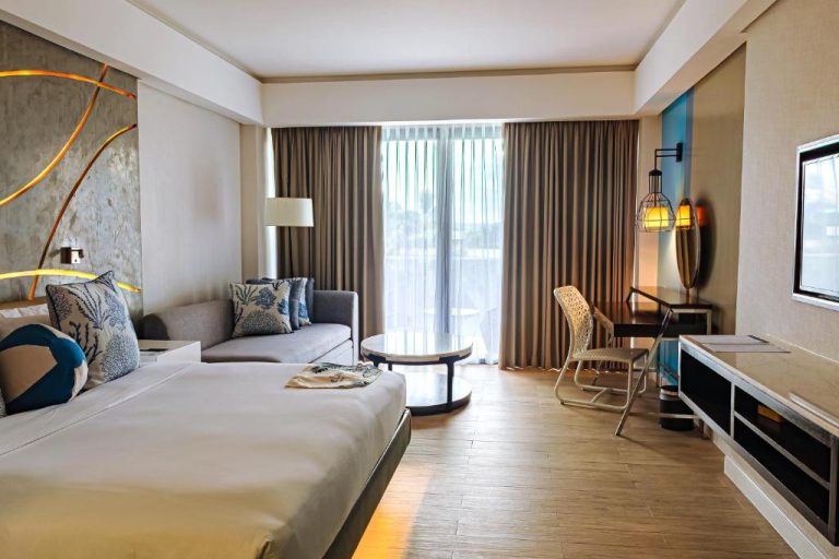 Habitación deluxe con cama king size y sofá en The Lind Boracay, decoración moderna con vistas