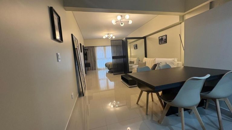 Salón comedor moderno con mesa oscura y sillas azules en Centro Histórico Apart I