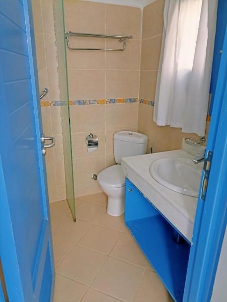 Baño completo con lavabo, inodoro y ducha acristalada en el Kanabesh Hotel