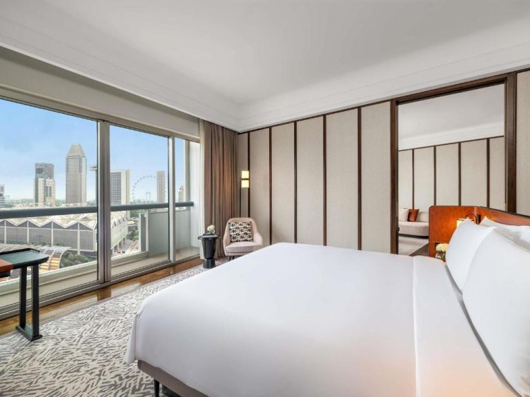 Habitación deluxe con cama king y vistas panorámicas al skyline de Singapur en Fairmont Singapore