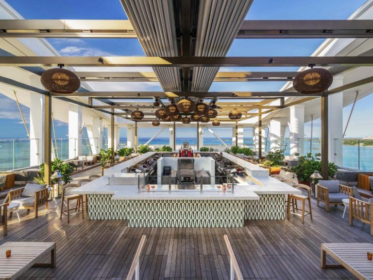 Bar en terraza rooftop con vistas al mar turquesa en el hotel SLS at Baha Mar en Nassau
