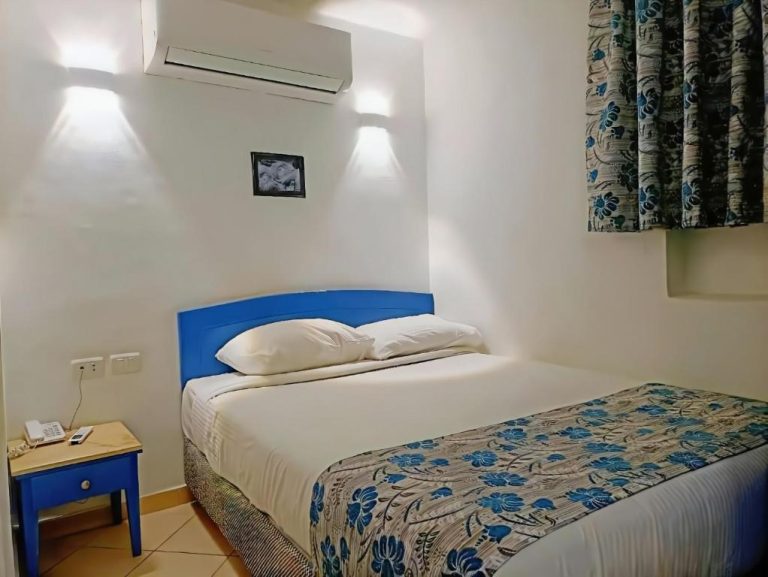Habitación doble con cabecero azul y aire acondicionado en el Kanabesh Hotel