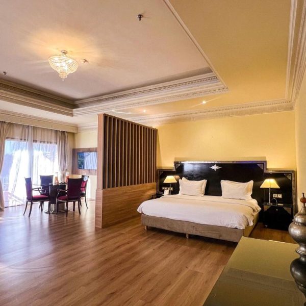 Suite de lujo con cama doble y zona de comedor del Hotel Royal Mirage Deluxe