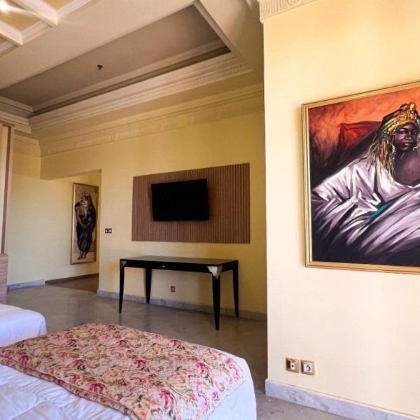 Habitación con arte africano y televisor del Royal Mirage Deluxe, decoración orientalista y cama doble