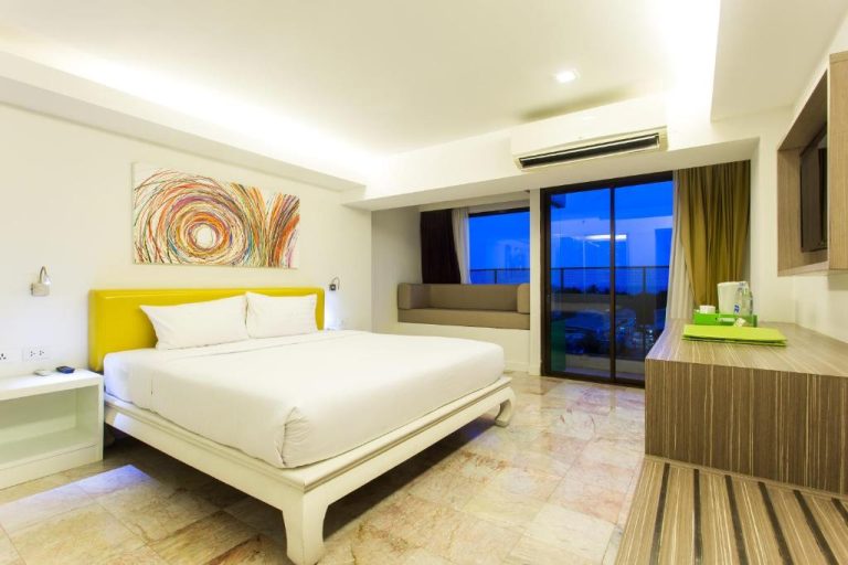 Habitación doble con cama king, cabecero amarillo y balcón con vistas al mar en Hotel Samui Verticolor