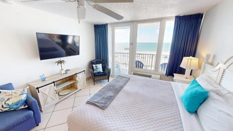 Habitación con cama doble y vistas al mar en Island Inn Beach Resort con balcón y decoración costera