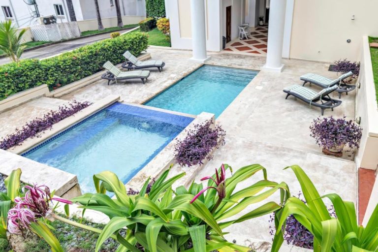 Piscina exterior con jacuzzi y tumbonas rodeada de plantas tropicales en Sea Vue Luxury Vacation Condominiums