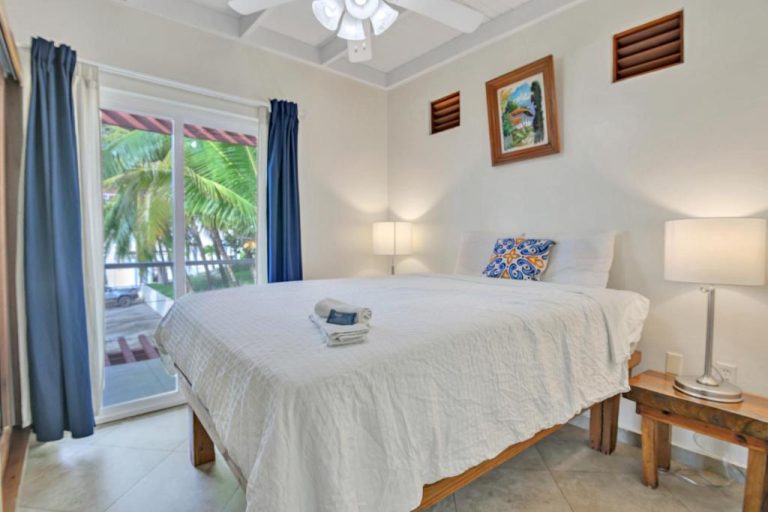 Habitación doble con cama king y vistas a palmeras tropicales en Sea Vue Luxury Vacation Condominiums