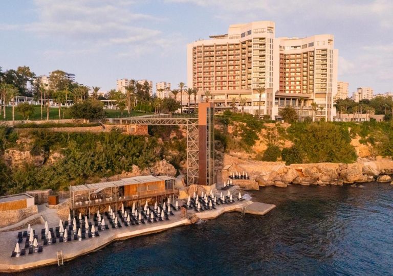 Playa privada con tumbonas y ascensor en el acantilado del Hotel Akra Antalya junto al mar
