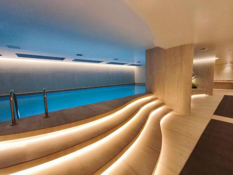 Piscina interior con iluminación LED y zona de descanso en Adagio Quito Coliving Ecuador Residences