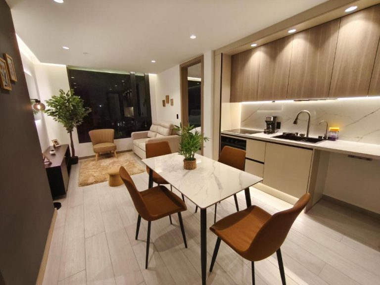 Cocina y comedor moderno con mesa de mármol y sillas en Adagio Quito Coliving Ecuador Residences