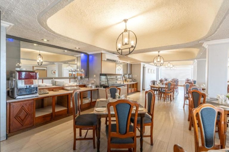 Restaurante con buffet de desayuno y mesas elegantes en el Gold Crest Hotel