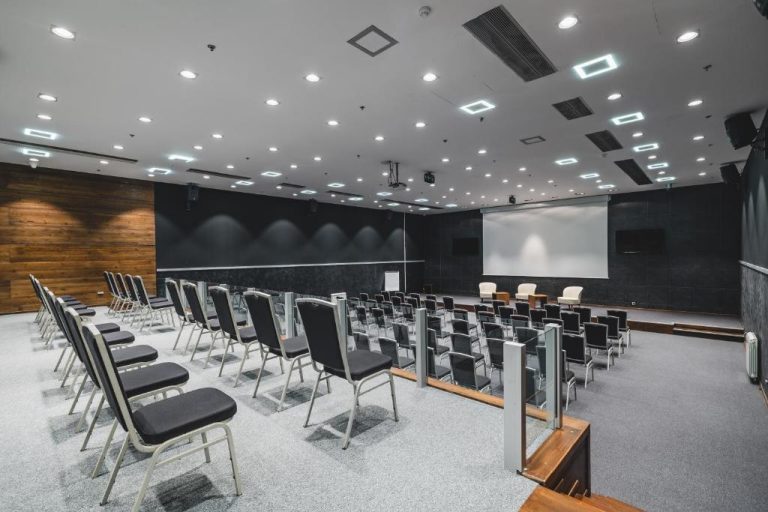 Sala de conferencias moderna con sillas y pantalla de proyección en Avala Resort & Villas