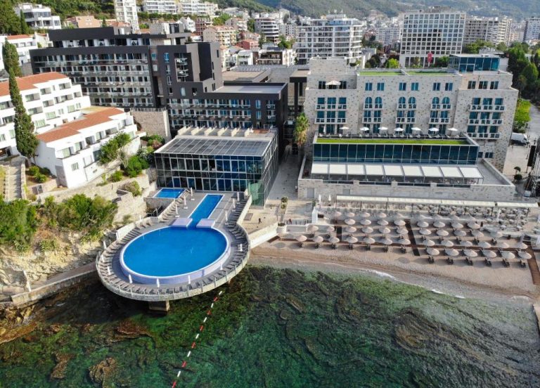 Vista aérea de la piscina exterior y playa privada del Avala Resort & Villas en Montenegro