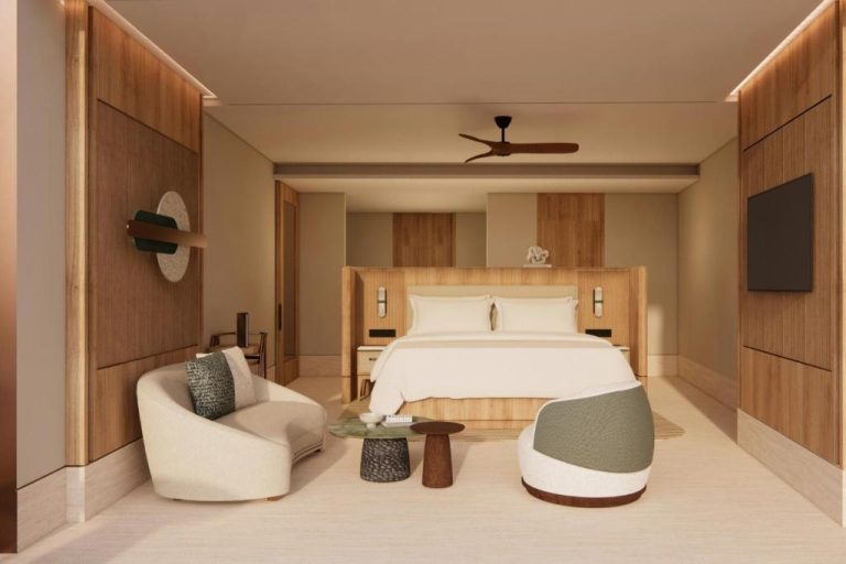Habitación suite de lujo con cama king y decoración en madera natural en The St Regis Costa Mujeres Resort Cancún