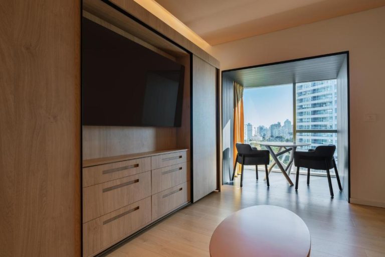 Habitación moderna con TV empotrada y terraza con vistas a la ciudad en The Grand Hotel