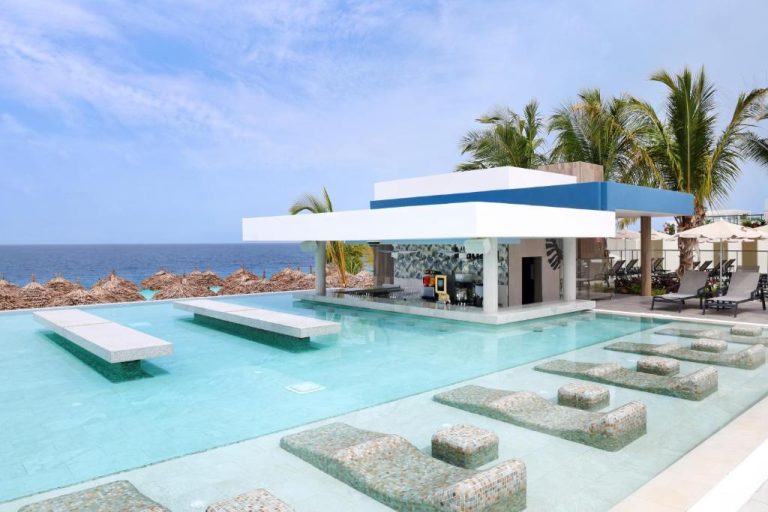 Piscina infinita con swim-up bar y tumbonas acuáticas del Riu Palace Swahili Adults Only frente al mar