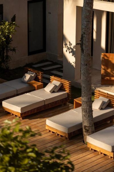 Tumbonas de madera con cojines en terraza exterior del Neem Boutique Hotel Madiha Adults Only