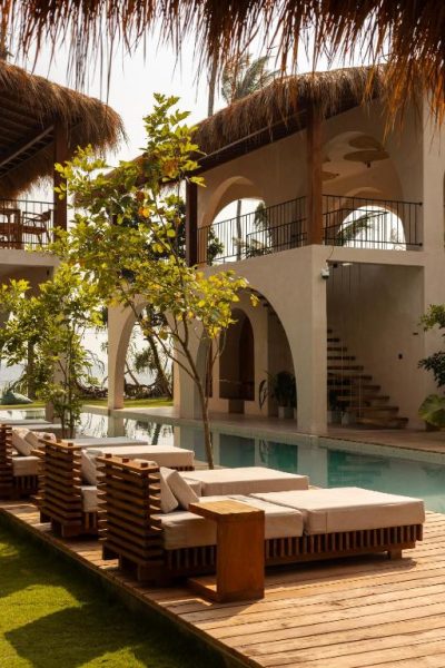 Piscina exterior con tumbonas de madera y arquitectura de arcos del Neem Boutique Hotel Madiha para adultos