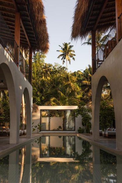 Piscina interior con arcos y palmeras tropicales del Neem Boutique Hotel Madiha para adultos