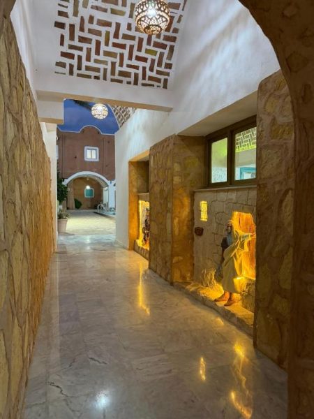 Pasillo con decoración tradicional beréber y figuras iluminadas en nichos del Hotel Matmata