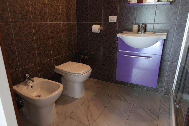 Baño completo con bidé, inodoro y lavabo morado moderno en Agriturismo I Pietrini