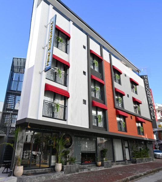 Fachada exterior del Nas Corner Hotel con balcones y toldos rojos en edificio moderno