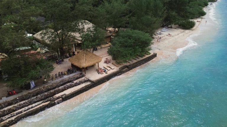 Vista aérea de la playa y gazebo con techo de paja del Villa Penyu en Gili Trawangan
