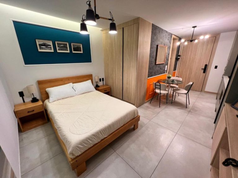 Habitación doble con cama matrimonial y zona de comedor en Adagio Quito Coliving Ecuador Residences