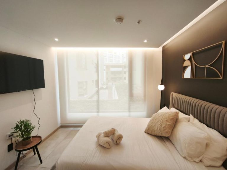 Habitación doble moderna con cama king y televisor en Adagio Quito Coliving Ecuador Residences
