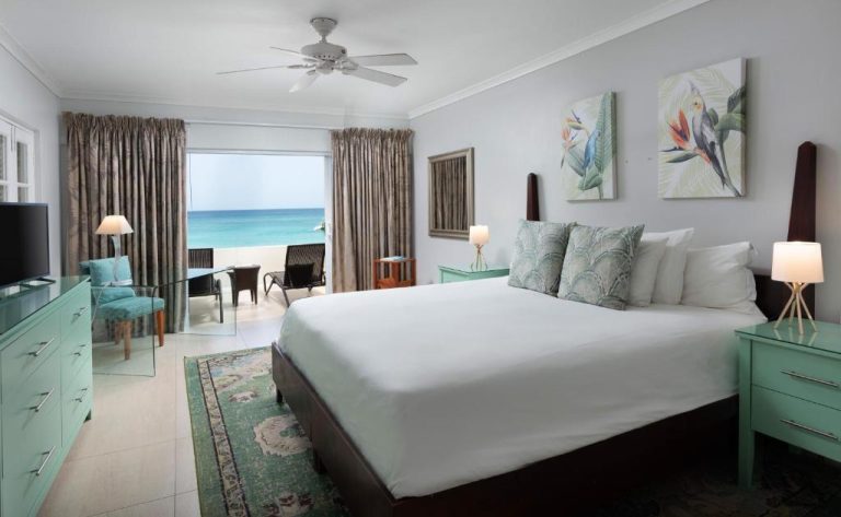 Habitación con cama doble y vistas al mar turquesa en Mango Bay All Inclusive Barbados
