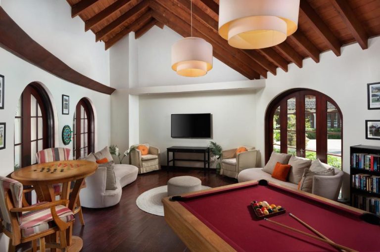 Sala de juegos con mesa de billar, sofás y televisión en el Mango Bay All Inclusive