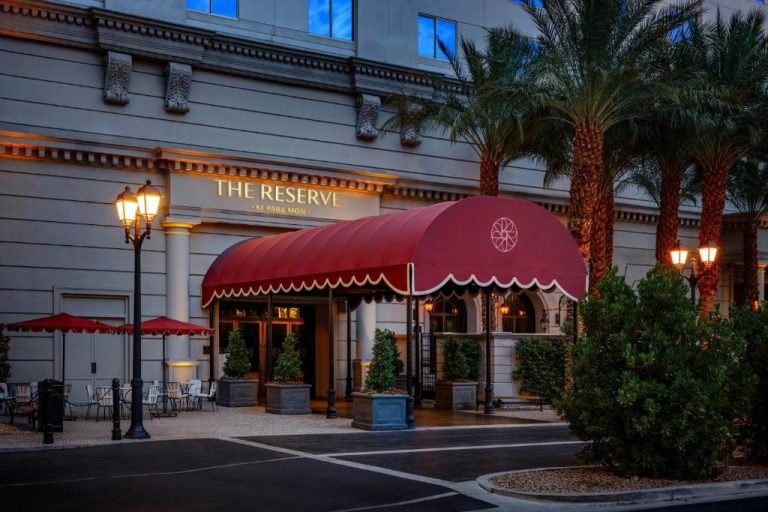 Entrada principal de The Reserve at Park MGM con marquesina roja y palmeras al atardecer
