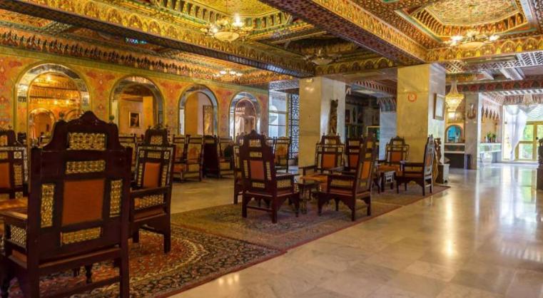 Suntuoso salón con decoración árabe y sillas talladas en madera del Hôtel Jugurtha Palace