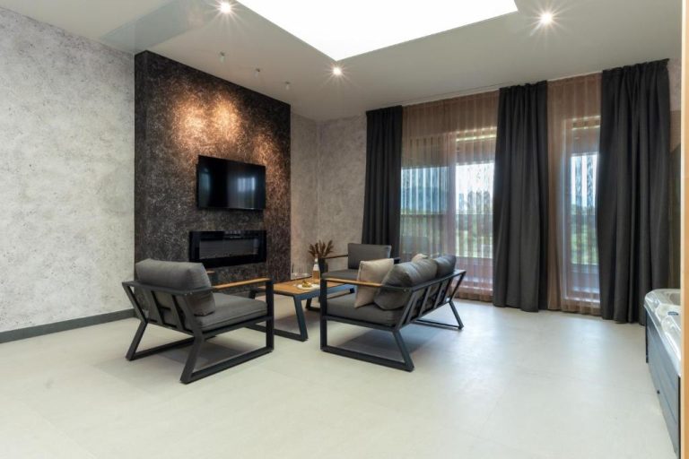 Salón moderno con chimenea, sofás y TV en Atmosphere Balneo Hotel & SPA