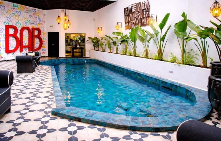 Piscina interior con azulejos turquesa y vegetación tropical en BAB Hotel Marrakech Boutique & SPA