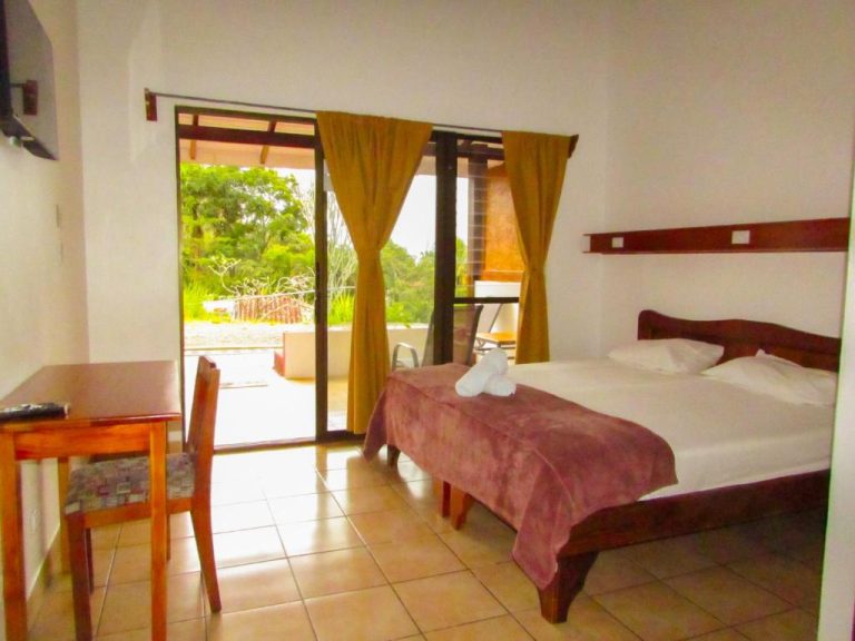 Habitación doble con terraza y vistas al jardín en Hotel Colinas del Sol con cama matrimonial