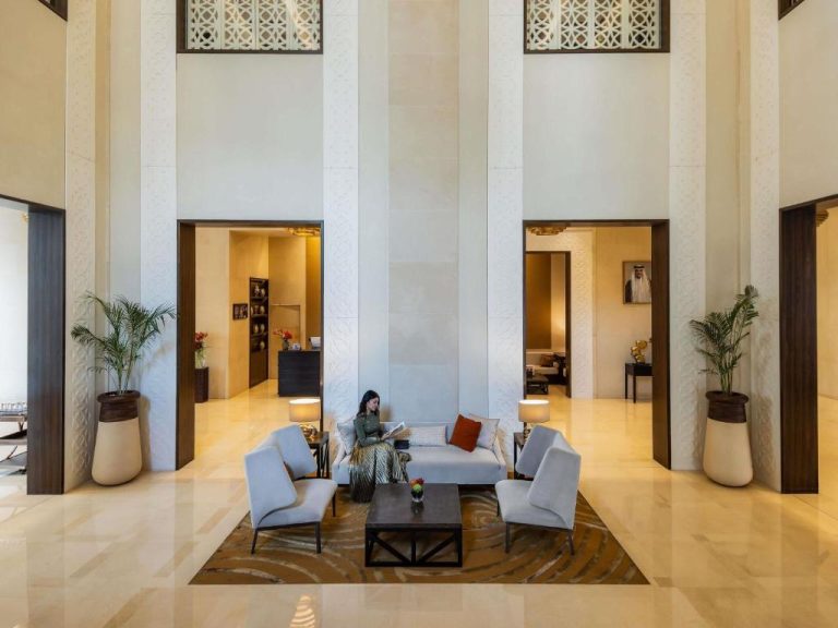Lujoso lobby del Alwadi Hotel Doha MGallery con techos altos, sofás y decoración árabe contemporánea