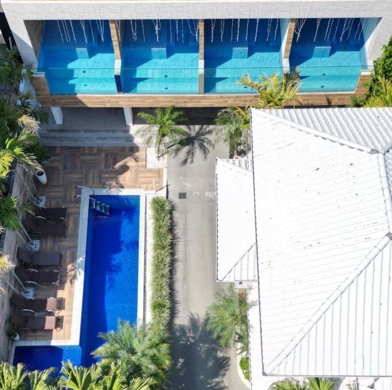 Vista aérea de la piscina exterior y jacuzzis privados de Pousada Exclusive rodeados de palmeras