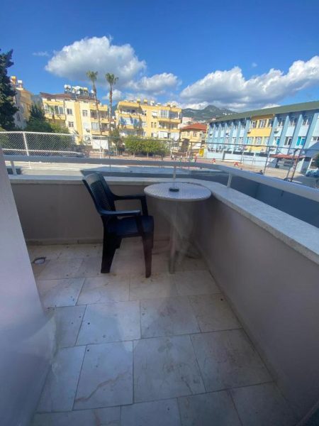 Terraza exterior con silla y mesa del Hotel Alanya Afd con vistas a los edificios de Alanya