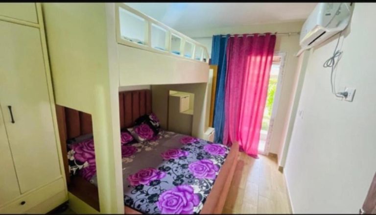 Habitación con litera y ropa de cama floral morada en Estudio Garden con aire acondicionado