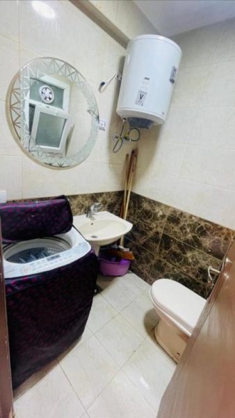 Baño completo con lavadora, sanitario, lavabo y calentador de agua en Studio Garden