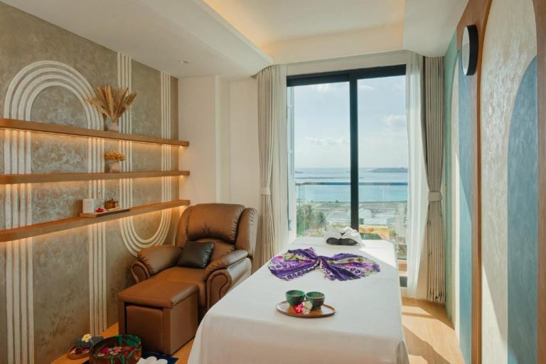 Sala de tratamientos spa con camilla y vista al mar turquesa en el hotel H78 Guraidhoo Maldivas