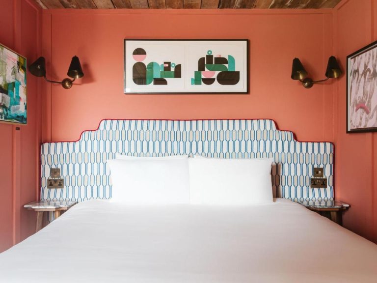 Habitación doble con cabecero estampado azul y paredes coral en The Dean Galway