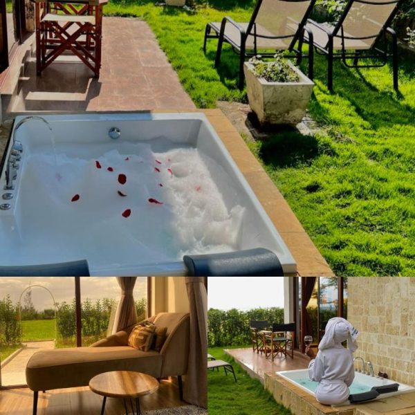 Jacuzzi exterior con pétalos de rosa y jardín verde en Lake Elementaita Manor, vista de suite de lujo con bata de baño