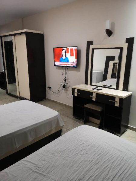 Habitación doble con dos camas, televisión y tocador en Mirage Bay Resort & Aqua Park