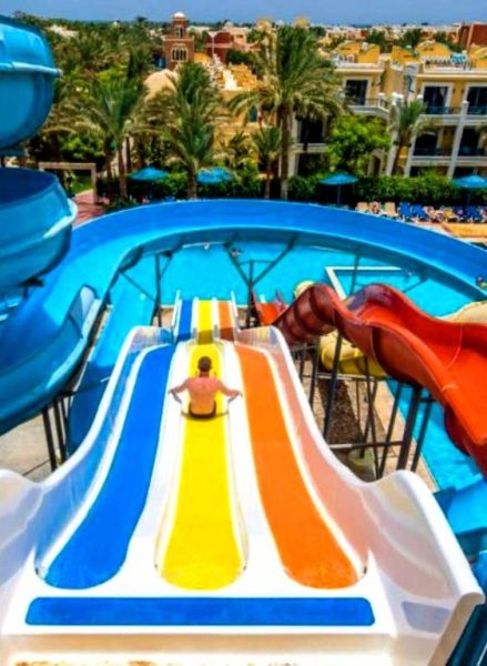 Toboganes acuáticos de colores con vistas a la piscina exterior del Mirage Bay Resort & Aqua Park