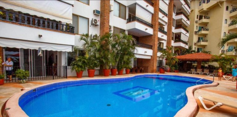 Piscina exterior con jacuzzi integrado y palmeras del Hotel Playa Bonita rodeada de edificios