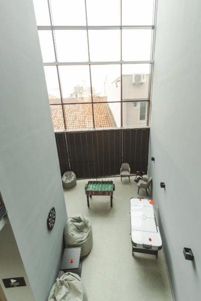 Sala de juegos con futbolín, air hockey y pufs en Garni Hotel MB Premium con ventanal