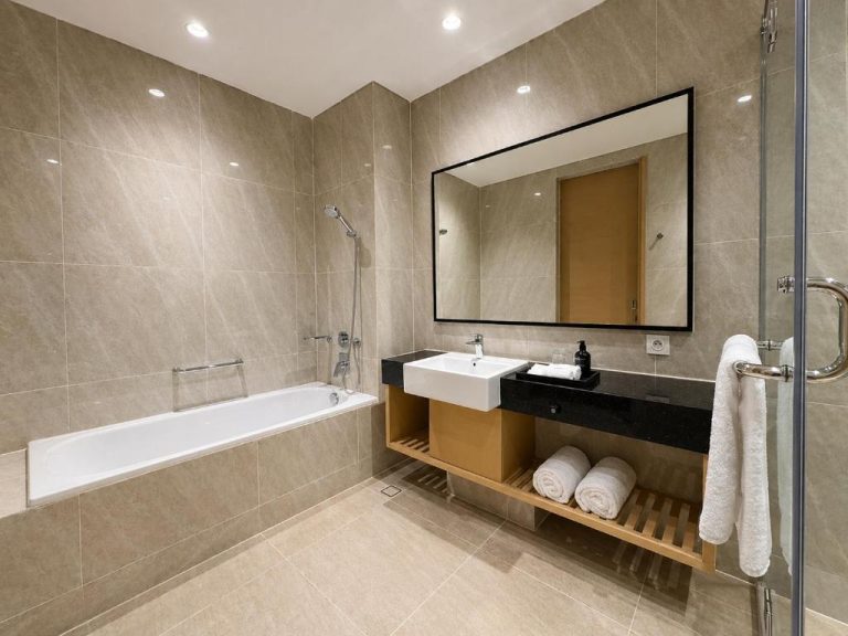 Baño completo con bañera, ducha y lavabo del Prime Plaza Hotel Mataram con acabados en mármol